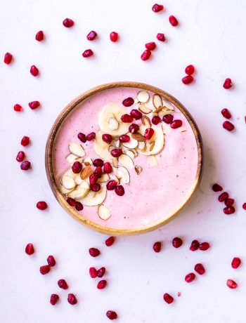 pink smoothie in bowl with pomegranate seeds