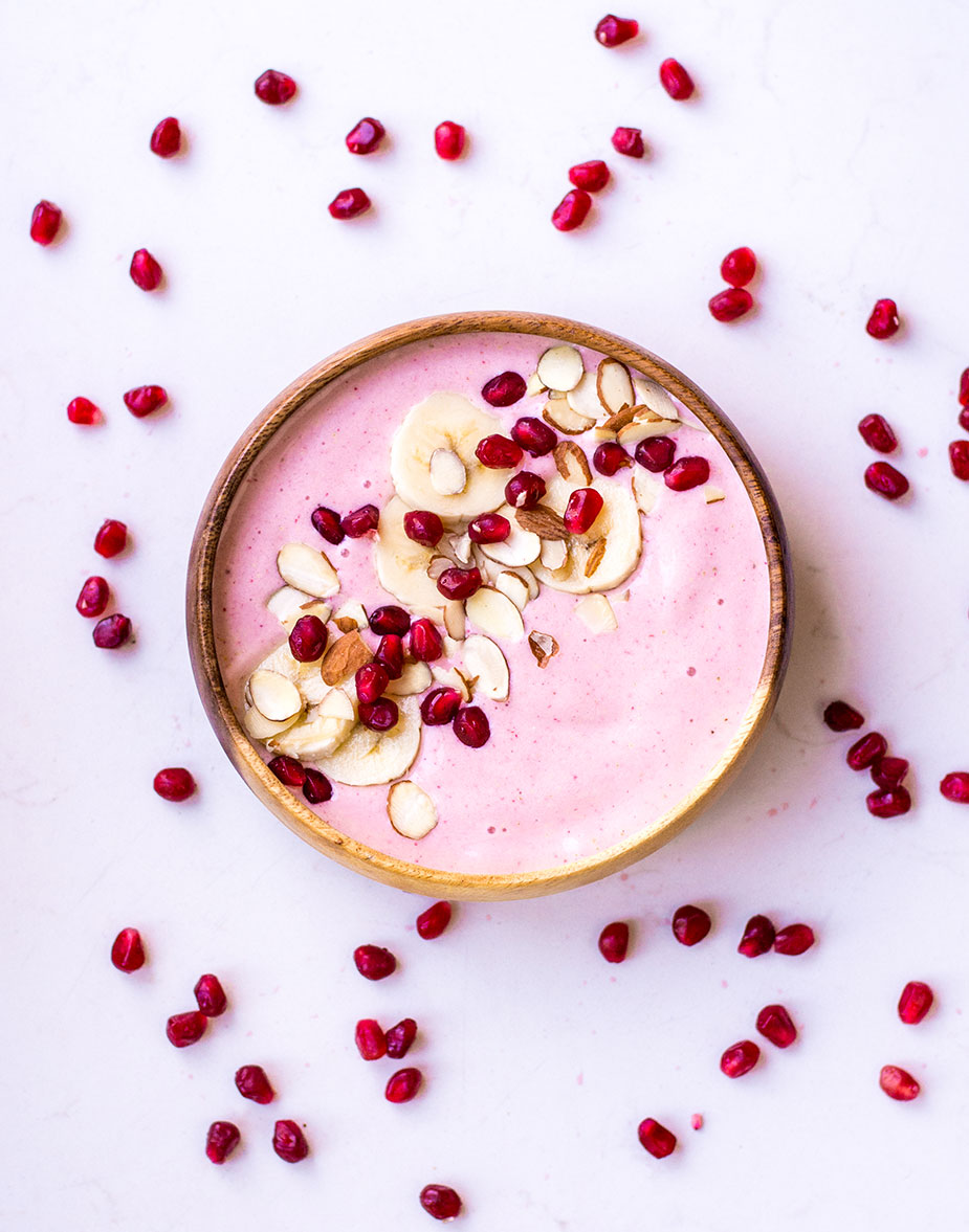 pink smoothie in bowl with pomegranate seeds