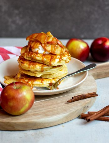 Caramel apple pancakes stacked on plate with caramel drizzle