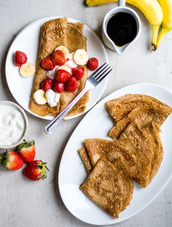 crepes on white background with strawberries and bananas