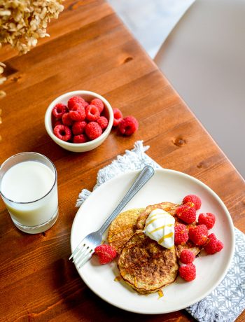 pancakes on wooden table with raspberries