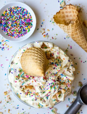 birthday cake ice cream on table with cone and sprinkles